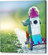 Child On Tricycle Carrying A Toy Space Rocket Canvas Print