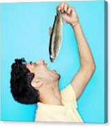 Man Eating Whole Fish Canvas Print