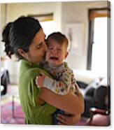 Mother Holding And Kissing Crying Baby Boy (12-17 Months) (focus On Foreground) Canvas Print