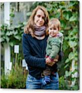 Mother With Her Child Standing In Community Garden Canvas Print