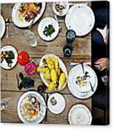 Overhead View Of Friends Dining Mid-meal Canvas Print