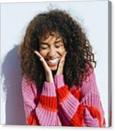 Portrait Of Laughing Young Woman With Curly Hair Against White Wall Canvas Print