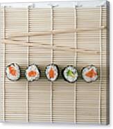 Sushi And Chopsticks On A Wooden Mat Canvas Print