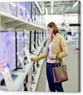 Woman Chooses A Tv In The Store Canvas Print