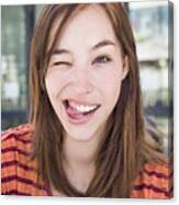 Young Woman Winking With Her Tongue Out Canvas Print