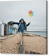 Boy Balancing On A Wall At The Beach Playing With A Windmill Canvas Print