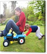 Boy Pushing His Father On Tractor Canvas Print