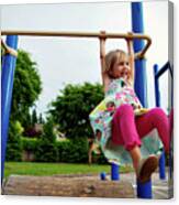 Cheerful Girl Hanging On Monkey Bars In Park Canvas Print