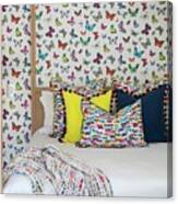 Colourful Scatter Cushions On Modern Four-poster Bed Against Butterfly-patterned Wallpaper Canvas Print