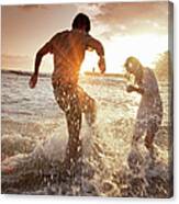 Couple Playing In Waves At Beach Canvas Print