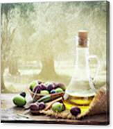 Olives And Bottle Of Olive Oil On Wooden Table In Olive Garden Canvas Print