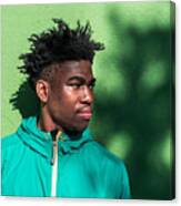 Portrait Of Serious Black Boy On Green Wall Background. Canvas Print