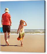 Rear View Of Granddaughter And Grandmother Walking On Sand At Beach Canvas Print