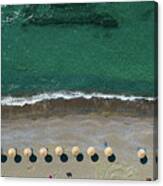 Aerial View From A Flying Drone Of Beach Umbrellas In A Row On An Empty Beach With Braking Waves. Canvas Print