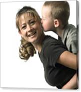 An Adult Caucasian Mother Holds Her Young Son As He Leans In To Kiss Her Canvas Print