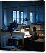 Businesswoman Examining Documents At Desk At Night Canvas Print