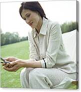 Businesswoman Using Cell Phone On Chair Outdoors, Close-up Canvas Print