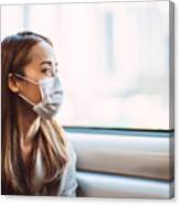 Businesswoman With Protective Face Mask Looking Out Of The Window Of Train In Thought Canvas Print
