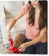 Caucasian Woman Tying Ribbon Around Pet Dog Canvas Print