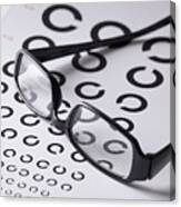 Close-up Of Glasses On Eye Exam Chart Canvas Print
