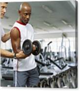 Coach Helping A Mid Adult Man Exercise With Dumbbells Canvas Print