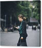 Confident Businesswoman Using Smart Phone While Crossing Street In City Canvas Print