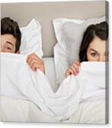 Couple In Bed Peeking Behind Duvet Canvas Print