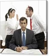 Executives With Halo And Devil Horns Standing Behind Businessman Canvas Print