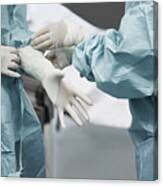 Female Doctor Helping Surgeon Wearing Glove Canvas Print