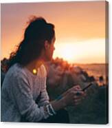 Girl At The Beach Texting On Sunset Canvas Print