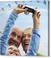 Grandparents And Granddaughter With Digital Camera Canvas Print