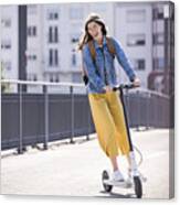 Happy Young Woman Riding Electric Scooter On A Bridge Canvas Print
