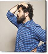 Man In Blue Shirt With Hand On Head And Hip Canvas Print