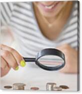 Mixed Race Woman Examining Stacks Of Coins With Magnifying Glass Canvas Print