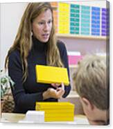 Montessori Teacher Helping Students In Classroom Canvas Print