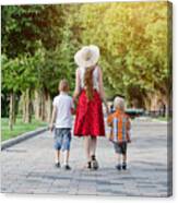 Mum And Two Sons Walking In The Park, Sunny Day. View From The Back Canvas Print
