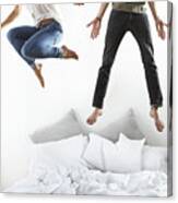 Portrait Of Couple Jumping On Bed Canvas Print