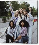Portrait Of Female Friends Gesturing With Peace Sign On Street Canvas Print