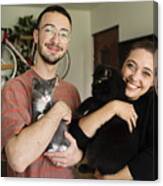 Portrait of millennial couple and newly adopted kitten at home. Canvas Print