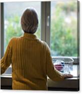 Senior Woman Standing Near The Kitchen Sink And Looking Through Window Canvas Print