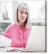Serious Looking Senior Woman With Laptop And Paperwork Canvas Print