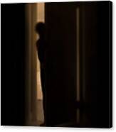 Silhouette Of Person Peeking Into Dark Room Through A Cracked Door Canvas Print