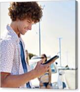 Smiling Young Man At A Car Checking His Cell Phone Canvas Print