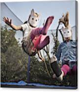 Two Children Wearing Rabbit Masks And Bouncing On A Trampoline Canvas Print