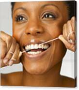 Woman Cleaning Teeth With Dental Floss, Close Up, Studio Shot Canvas Print