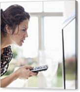 Woman Holding Remote Control To Tv And Squinting Canvas Print