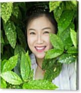 Young Asian Woman Standing Behind Green Leaves Canvas Print
