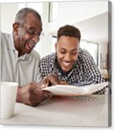 Young Black Man Looking At A Photo Album At Home With His Grandfather, Close Up Canvas Print