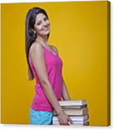 Young Woman Carrying A Pile Of Books Canvas Print