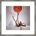 A Model Balancing A Red Ball On Her Feet Framed Print